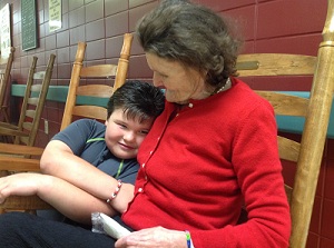 An elderly female patient is rocking with a sweet little boy.